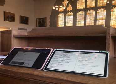 Image of of Two iPads Side-by-side on a Desk inside the Caven Library of Knox College at the University of Toronto. Photo Credits: Kylie Ng