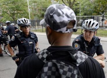 51 Division Constables Robyn Court, left, and Brent Larmour, right, speak with people near Seaton House, Toronto’s largest homeless shelter. Experts are struggling to explain why the crime rate is down in Toronto and the rest of Canada